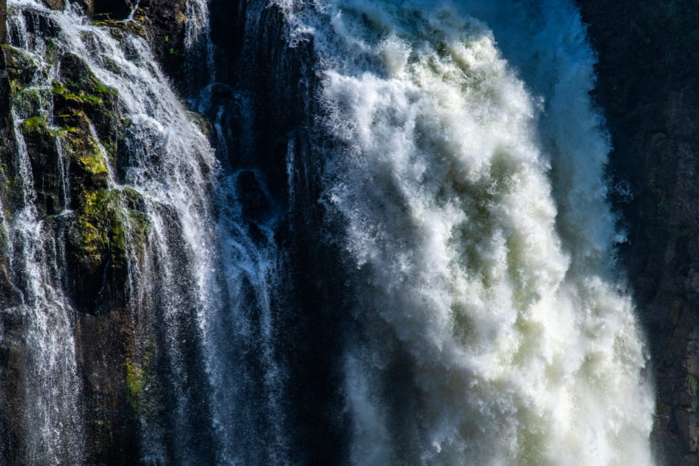 Close-up of a powerful waterfall cascading over rugged cliffs, symbolising the force and complexity of water.