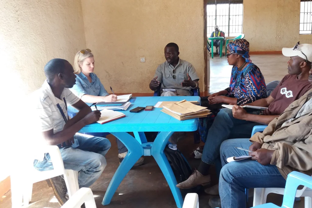 Digby Wells team members and stakeholders in a resettlement planning consultation, discussing livelihood restoration where replacement land is limited.